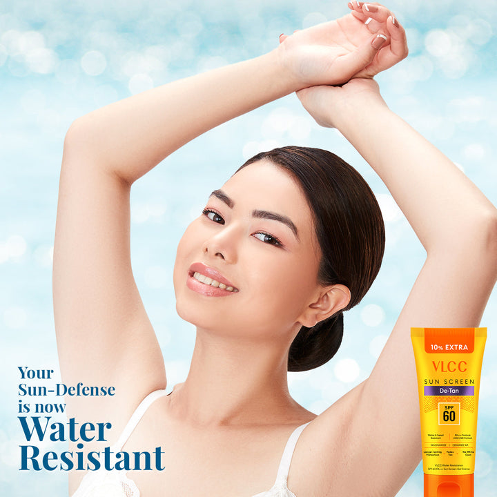 Woman with arms raised showing sun-protected skin, VLG Sun Screen tube on a light blue background